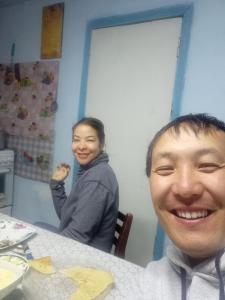 a young man sitting at a table with a woman at Mountain Horse Trekking Guesthouse in Karakol