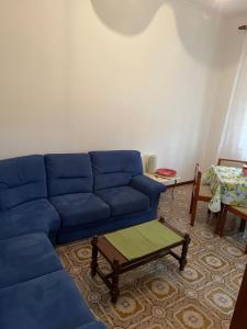 uma sala de estar com um sofá azul e uma mesa em da Lilia in Salute&Bellezza em Monfalcone