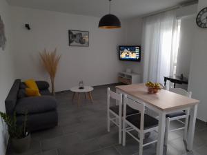 a living room with a table and a couch at Apartman Mihaela in Rab