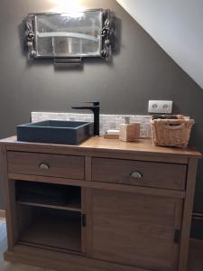 a bathroom vanity with a sink and a mirror at chambres d'hôtes Le Carillon in Bergues