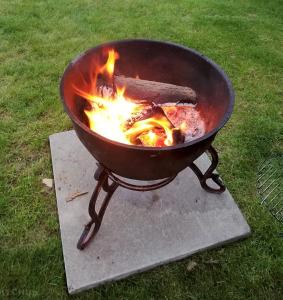 a grill with fire in it on the grass at Archers Meadow Shropshire in Ellesmere
