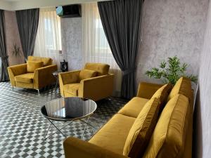 a living room with a couch and chairs and a table at Seasons-Top of the city in Braşov