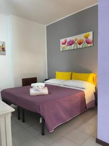 ein Schlafzimmer mit einem Bett mit einer lila Decke in der Unterkunft monolocale 2 LudoLeo 5p in Quartu SantʼElena