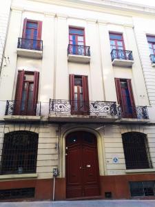 un immeuble d'appartements avec des portes rouges et des balcons dans l'établissement Posada Del Gaucho, à Montevideo