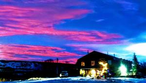 a house in the snow with a pink sky at Duck Lake Lodge in Babb