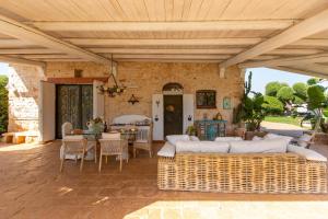 a patio with wicker furniture and a wooden ceiling at Villa Letto D'Alloro - Royal Dream in Conversano