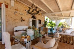 a living room with a glass table and chairs at Villa Letto D'Alloro - Royal Dream in Conversano