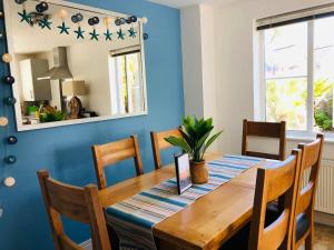 a dining room with blue walls and a wooden table and chairs at Starfish Cottage in Charlestown
