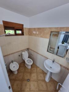 un bagno con due wc, un lavandino e uno specchio di Studio Vlora a Vlorë