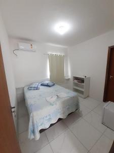 um quarto com uma cama num quarto branco em Hotel Janaína em Porto Belo
