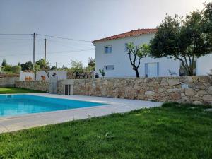 a villa with a swimming pool and a stone wall at Casa dos Picoutos AL in Monção