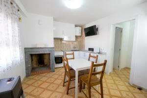 a kitchen with a table and chairs and a fireplace at Apartamento Paco 3 cerca de Valencia in Benafer