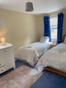 um quarto com 2 camas e uma janela em Modern 2 bedroom house with WIFI em Welwyn Garden City