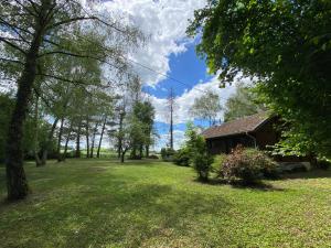 una casa en un campo con un patio con árboles en Maison 2 chambres proche Dijon chalet niché dans la nature, en Saint-Maurice-sur-Vingeanne