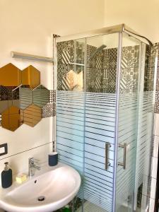 a bathroom with a sink and a glass shower at playa home in Catania