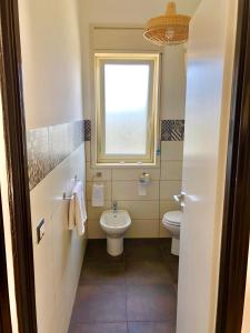 a bathroom with a toilet and a window at playa home in Catania