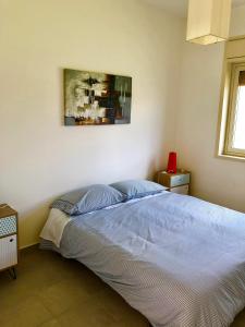 1 dormitorio con 1 cama con una pintura en la pared en playa home en Catania
