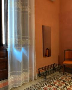 a room with a curtain and a chair and a window at A 'Du Passi in Castellammare del Golfo