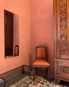 an orange chair sitting in a room with a mirror at A 'Du Passi in Castellammare del Golfo