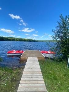 a dock with two boats on a lake at Silver Maple Motel in Haliburton