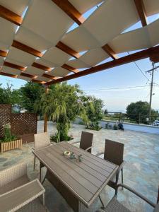 Une table et des chaises en bois sont disponibles sur la terrasse. dans l'établissement Petrichor houses, à Portariá