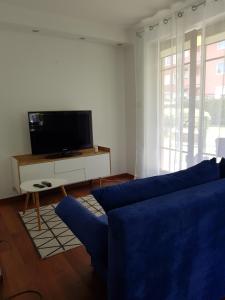 ソポトにあるMEwa Apartment Polnaのリビングルーム(青いソファ、テレビ付)