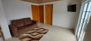 een woonkamer met een bruine stoel en een tapijt bij Casa de Ponta in Topo