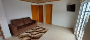 a living room with a brown chair and a rug at Casa de Ponta in Topo