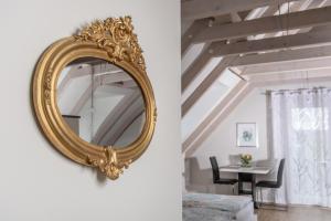 um espelho de ouro pendurado numa parede numa sala de estar em Ferienwohnung TonArt em Sommerach