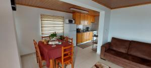 a kitchen and dining room with a table and a couch at Casa de Ponta in Topo