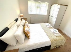 a bedroom with a bed with white pillows and a window at Apartment in Oxfordshire in Sunningwell