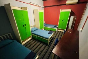 Habitación con 3 camas y paredes verdes en RHV Bukit Bintang , Kuala Lumpur, en Kuala Lumpur