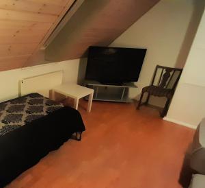 a bedroom with a flat screen tv and a bed at Sleep and Relax - Few minutes drive to the Ferry, Lalandia and the Femern Tunnel project in Rødby