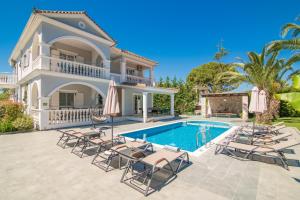 Villa con piscina y tumbonas en Luxury Villa Vanato & Pool en Koukounariá