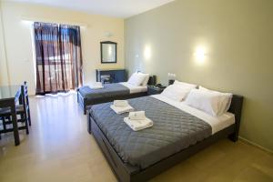 a bedroom with two beds with towels on them at Adonis Hotel in Mitikas