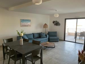 - un salon avec un canapé bleu et une table dans l'établissement Casa Olmia Résidence, à Calvi