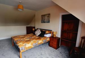 a bedroom with a bed and a wooden dresser at Jovie Apartment in Stornoway