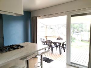 a kitchen and dining room with a table and a balcony at Camping in Le Muy
