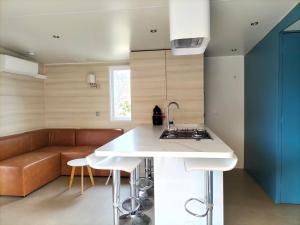 a kitchen with a stove and a couch in a room at Camping des Cigales in Le Muy