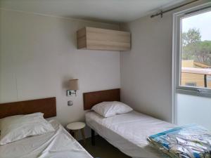 a bedroom with two beds and a window at Camping in Le Muy +16 photos