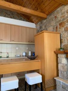 a kitchen with a counter and stools in a room at Aspa's Traditional House in Didyma