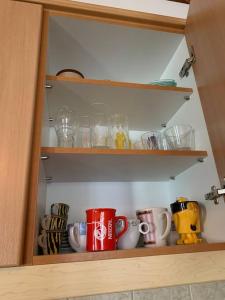 a cupboard with cups and mugs in it at Aspa's Traditional House in Didyma