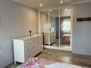 a bedroom with a dresser and a large mirror at Apartamento en sanxenxo Aldodi in Sanxenxo