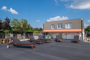 a deck with lounge chairs and a building at Hedon Brewing Niko apartment - 200 meter to the Beach in Balatonvilágos