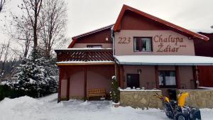 a building with a sign on it in the snow at Chalupa Ždiar in Ždiar