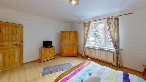 a bedroom with a bed and a window at Chalupa Ždiar in Ždiar
