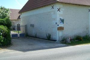 a white building with a sign on the side of it at petit gite in Rilly-sur-Loire
