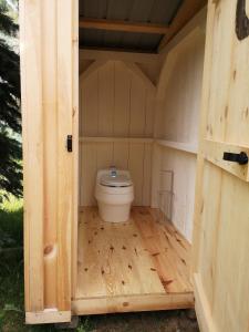 a bathroom with a toilet in a wooden door at Dreamers Writing Farm, 3 Wooded Acres, Hepworth in Sauble Beach