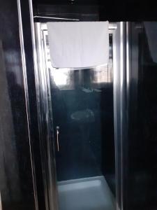 a glass door of a shower with a white curtain at The Coastal Bay Hotel in Blackpool