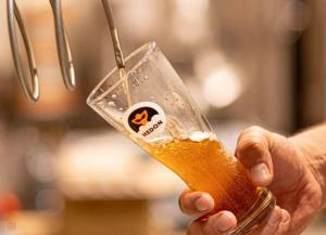 a person is holding a glass of beer at Hedon Brewing Balatonvilágosi apartment - 200 meter to the Beach in Balatonvilágos